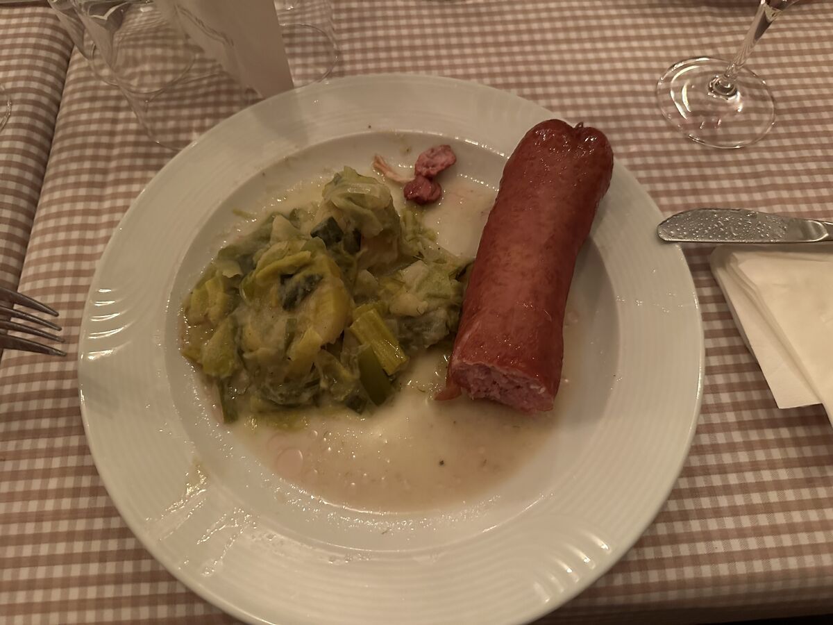 Treberwurst mit Kartoffel-Lauch-Gemüse auf einem gedeckten Tisch